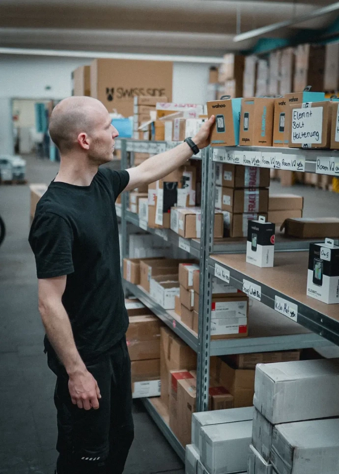 Ein Refresh Mitarbeiter nimmt ein Produkt aus dem Regal.